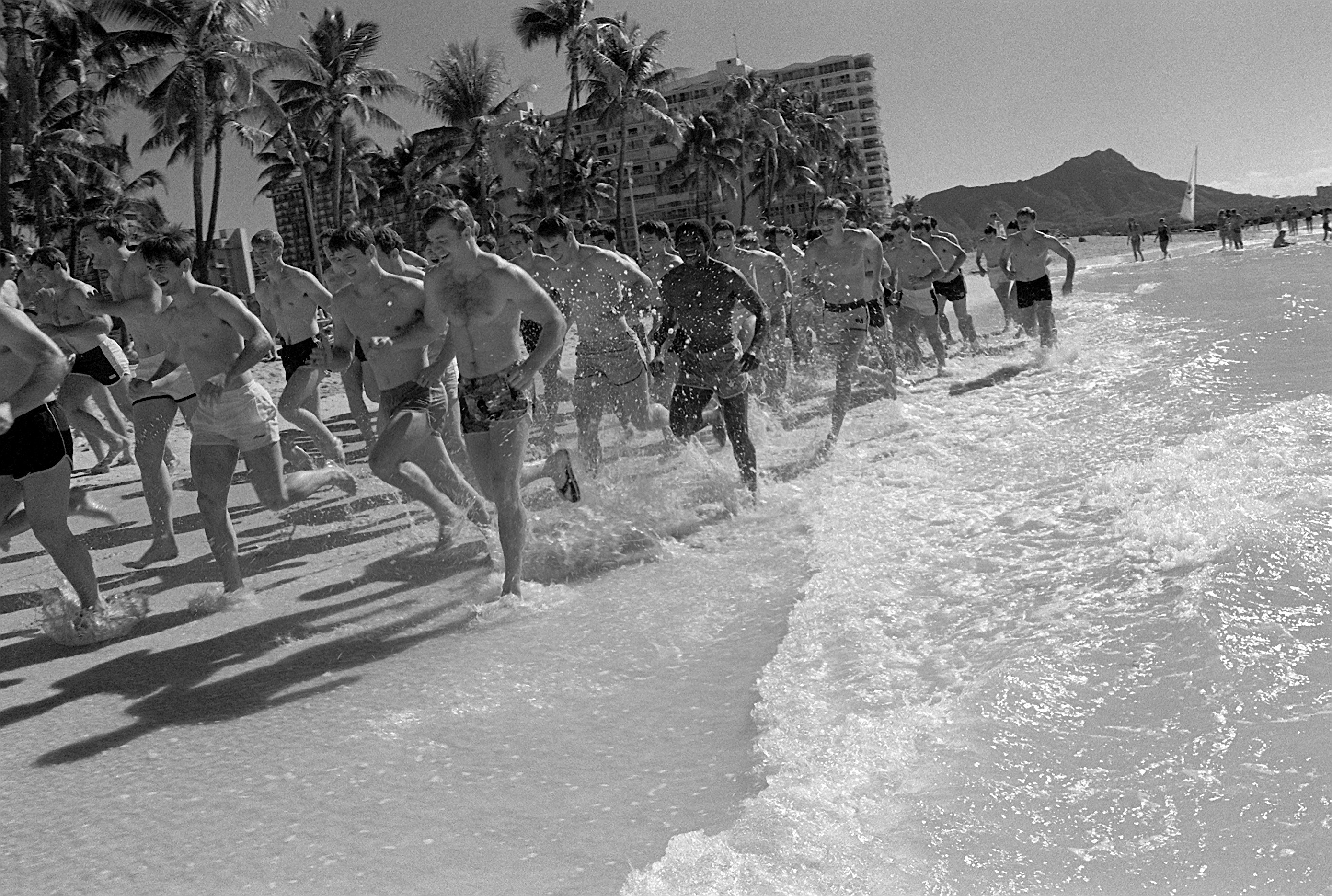 Members of the Air Force Academy football team job on Waikiki Beach before their game with the team from the University of Hawaii / Wikimedia Commons